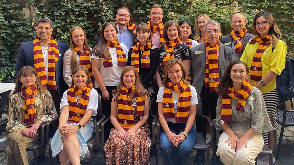 Mark Kuczewski and group of Ukrainian Fellows wearing scarves in Loyola colors of maroon and gold
